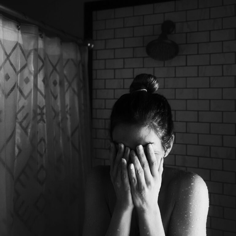 Woman crying in shower postpartum